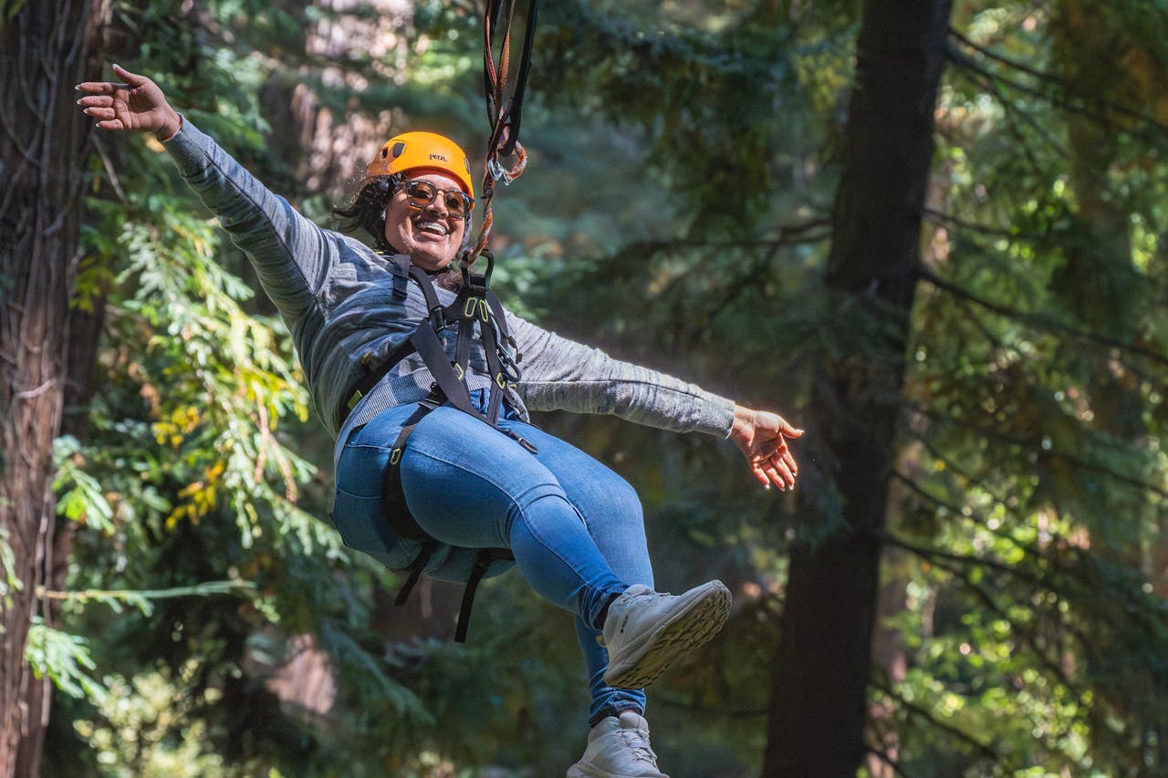 why-choose-us Woman ziplining through a lush forest, embracing adventure and enjoying the thrill of nature.