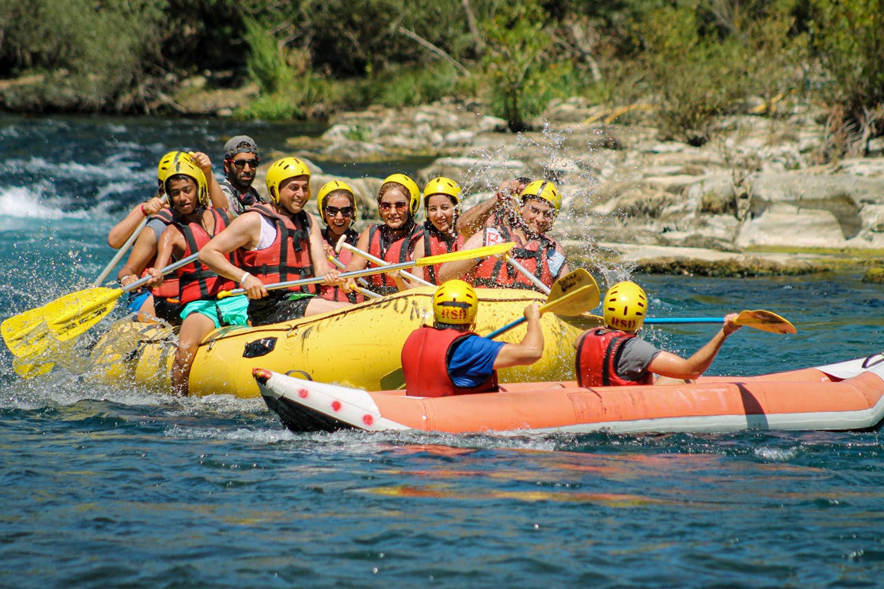 hero-img-01 Exciting river rafting excursion with a group wearing helmets and vests, paddling through rapids.