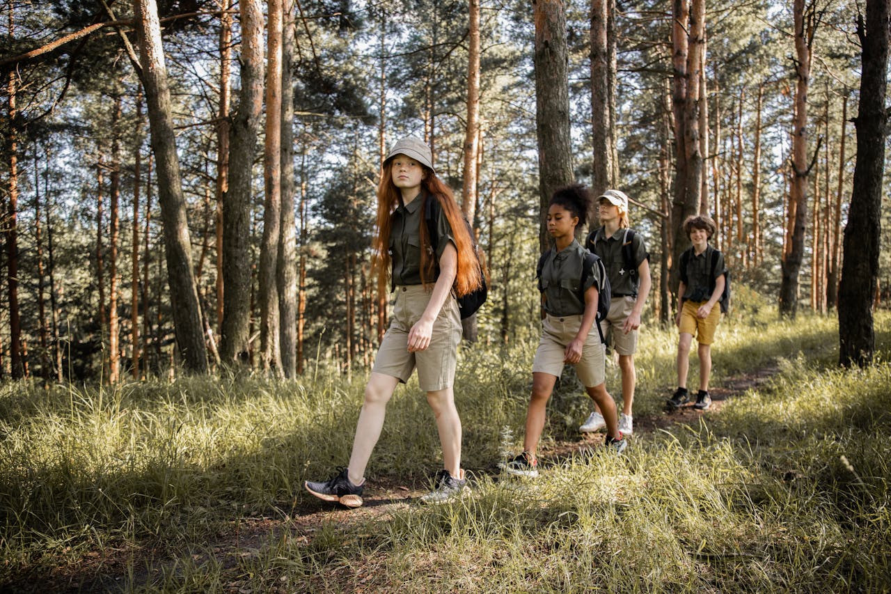 hero-img-02 Group of teenagers hiking through a forest trail, enjoying nature and exploration.